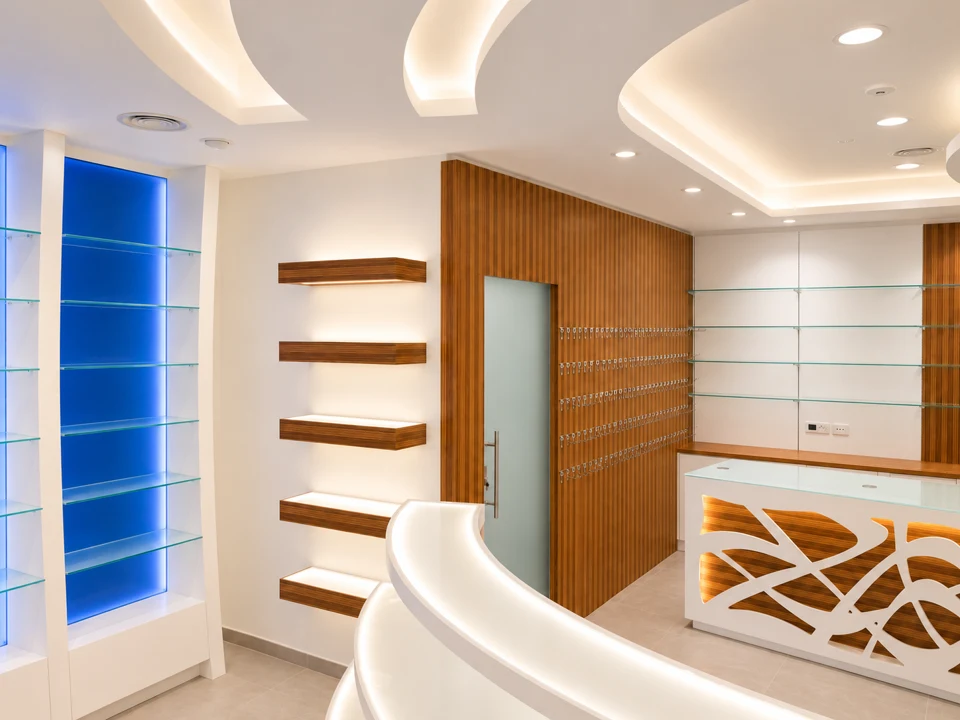 Curves and light: interwoven wood — White curved furniture, blue wall and organic front