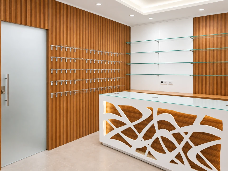 Curves and light: interwoven wood — White perforated counter, wood wall and door