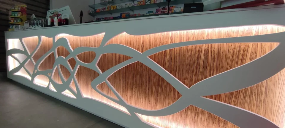 Counter detail with white openwork decoration and backlit wood backing