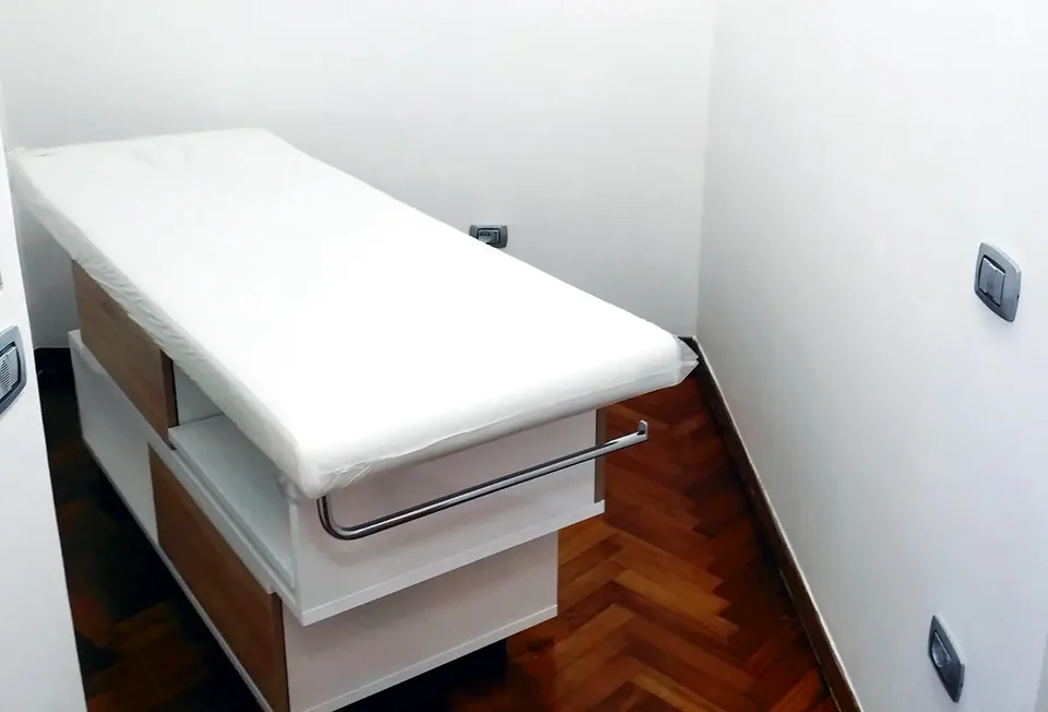 Treatment bed in a consultation room with white furniture