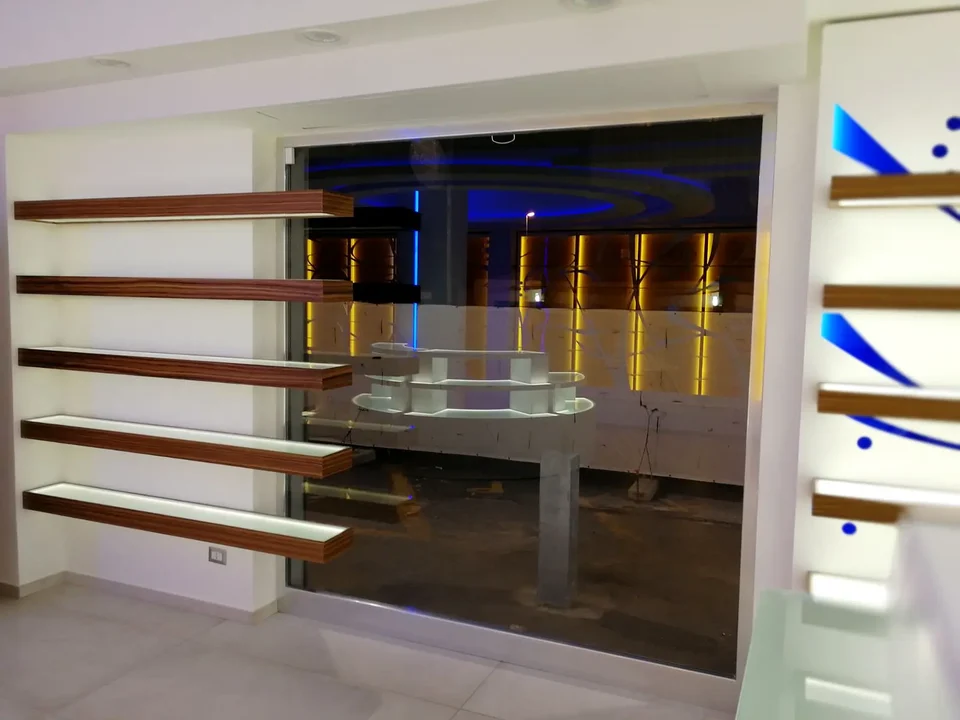 Wall module with timber shelves and blue lighting