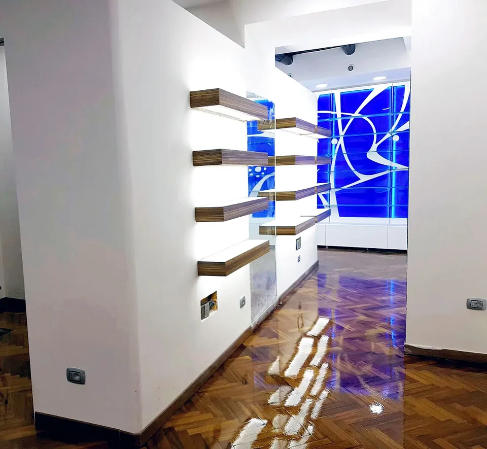 Interior passage with suspended shelving and blue display case