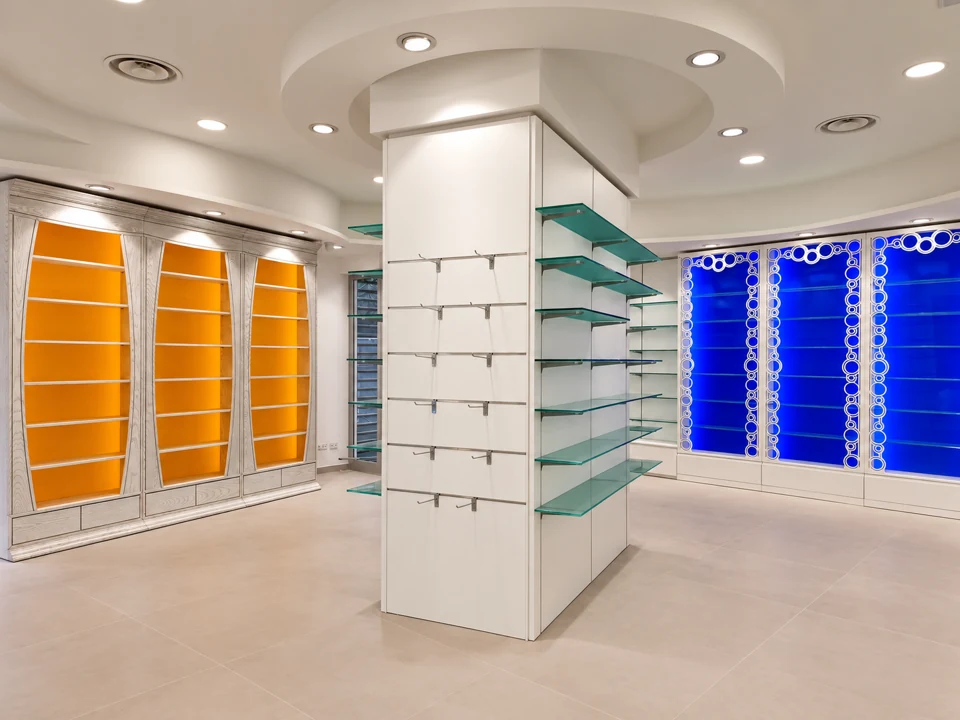 Central route between glass shelving and blue backlit walls