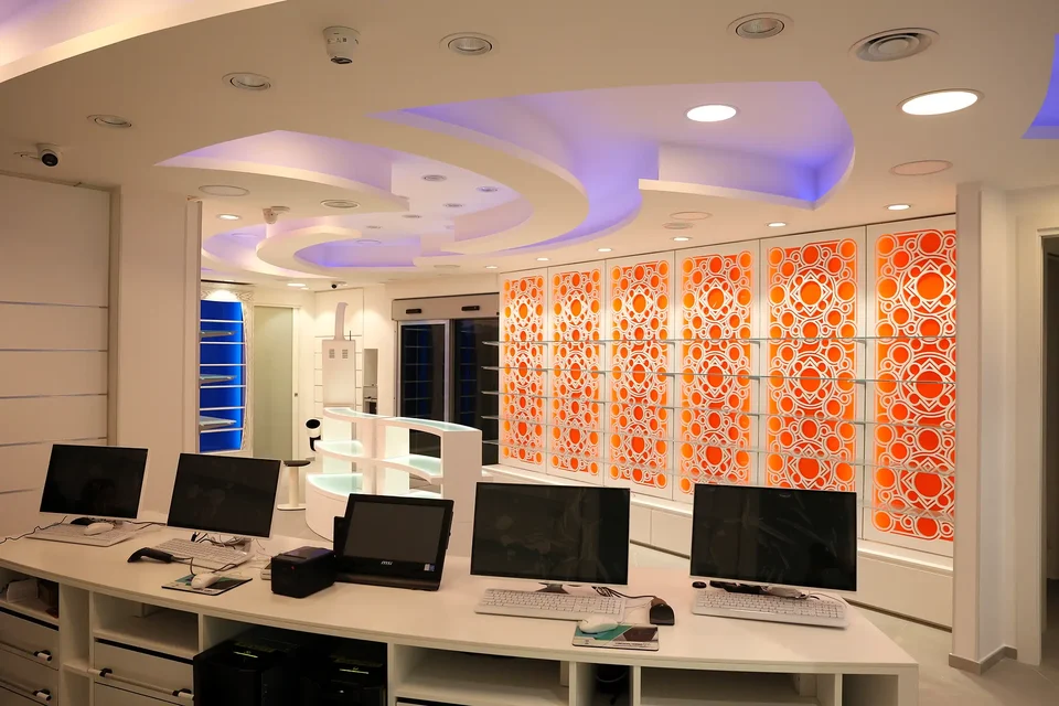 Workstations behind an orange perforated wall