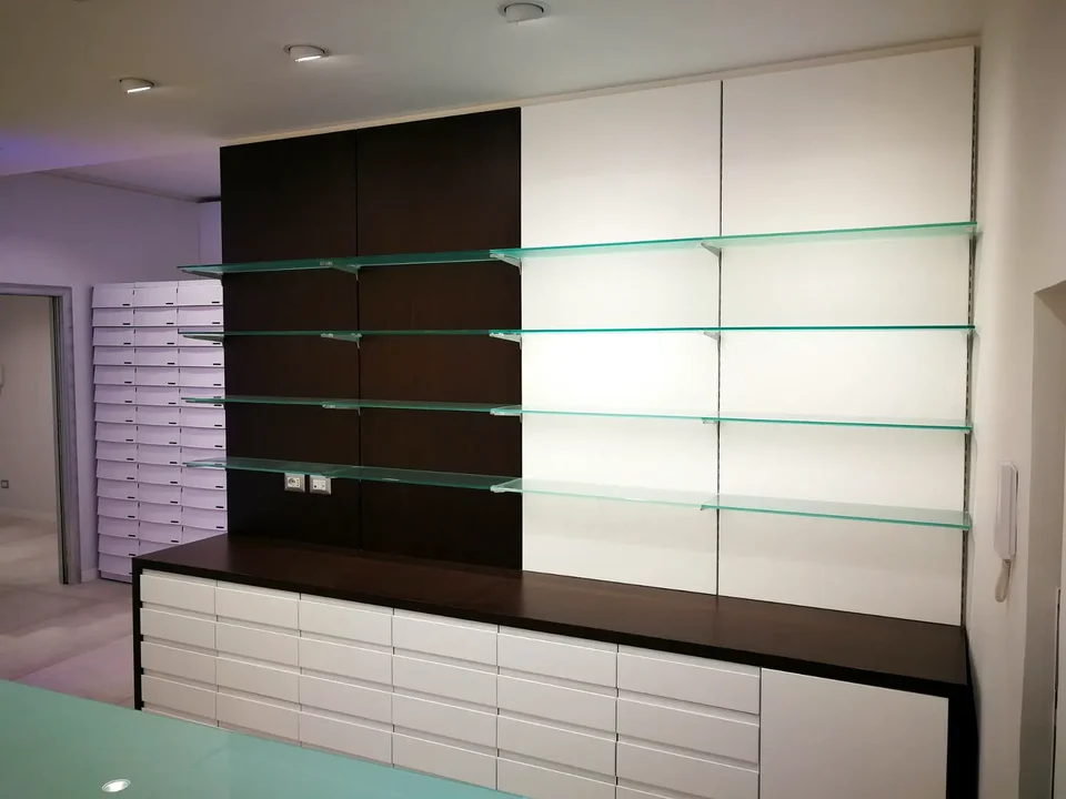 Linear shelving in dark timber and glass