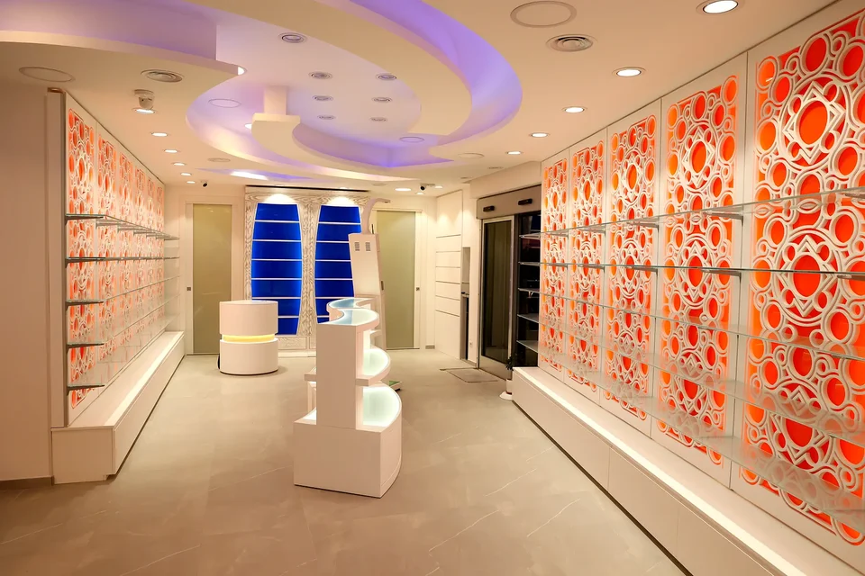 Wide view with perforated orange walls and white furniture