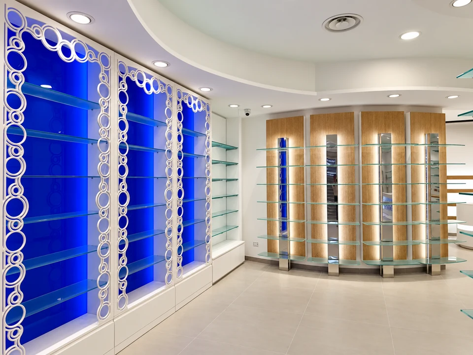 Farmacia Santa Rita: pareti blu, mensole in vetro e motivi circolari