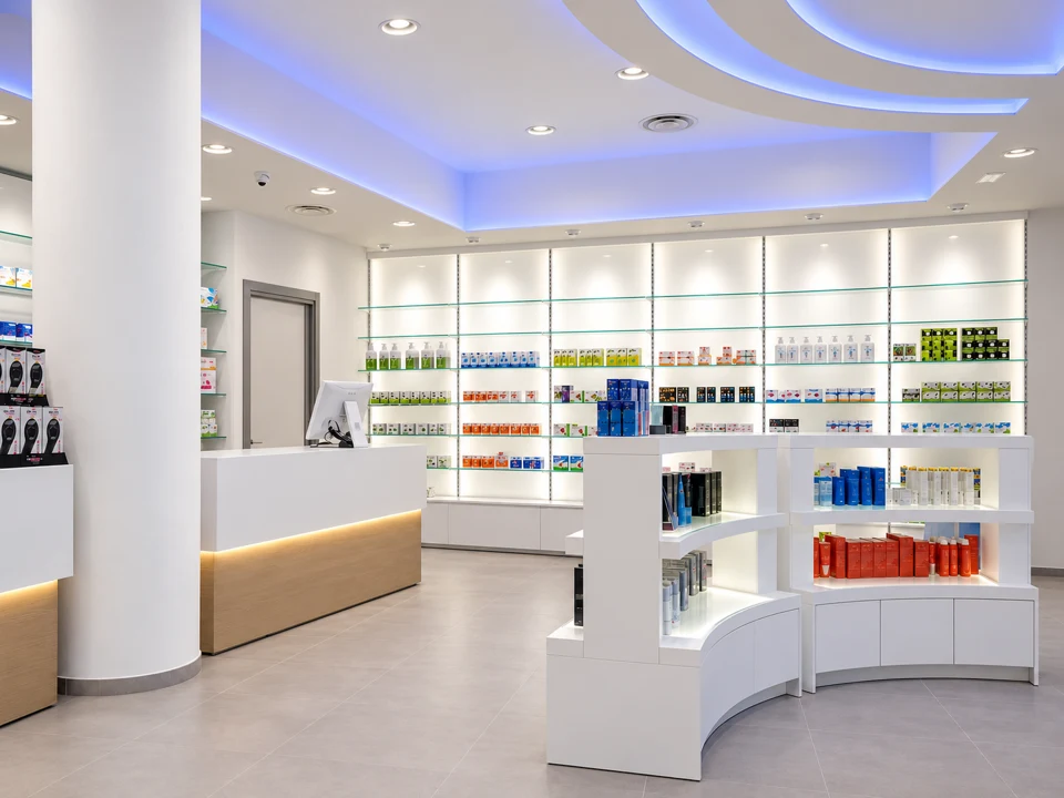 Wide view of a pharmacy with white islands and diffused lighting